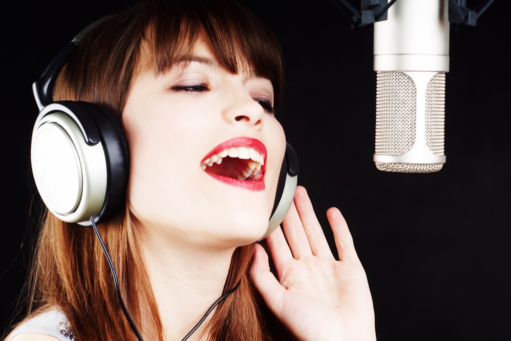 Как научиться петь песни. Девушка поет в микрофон в студии. Женщина поет в телефон. Девушка поет в студии звукозаписи. Привлекательный голос женский.